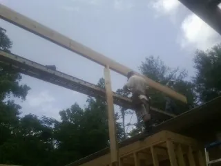 Carpenter setting a ridge beam over a new addition frame — Ice Dam Removal by Roofing Brothers in Greensburg