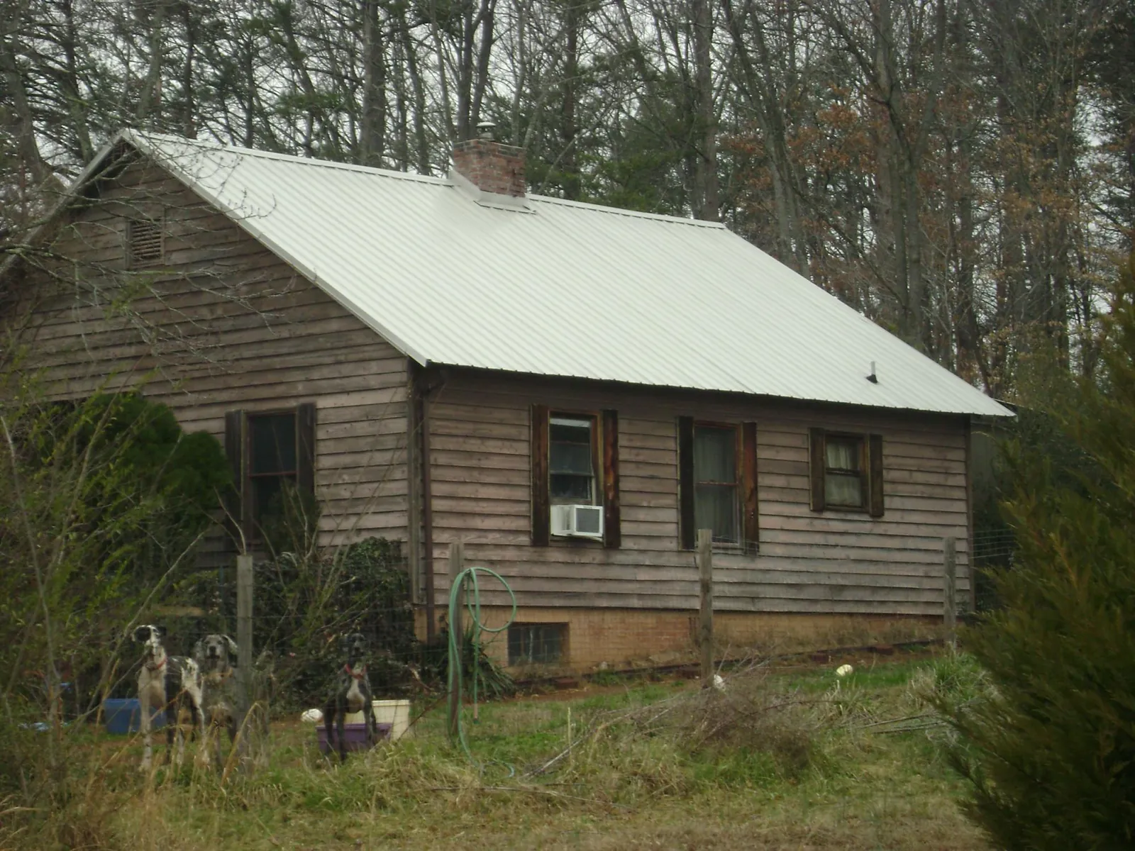 White metal roof on an old wood sided farmhouse, from a Asphalt Shingle Roof Repair job in Greensburg
